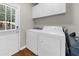 Functional laundry room with washer, dryer, storage cabinets, and access to backyard at 7610 Golden Sands Dr, Cumming, GA 30041