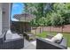 Cozy outdoor seating area with modern furniture, umbrella, privacy fence and landscaped backyard space at 146 Bellehaven Dr, Woodstock, GA 30188
