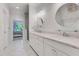 Bright bathroom featuring double sinks with a granite countertop, round mirrors and tiled floors at 146 Bellehaven Dr, Woodstock, GA 30188