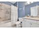 Well-lit bathroom with a tub and shower combination, a single sink vanity, and blue accent wall at 146 Bellehaven Dr, Woodstock, GA 30188