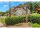 View of the community entrance sign amongst the lush landscaping and neighboring townhomes at 146 Bellehaven Dr, Woodstock, GA 30188