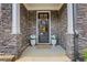Inviting front porch featuring stone accents, decorative wreath, and potted plants at 146 Bellehaven Dr, Woodstock, GA 30188