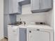 Well-organized laundry room featuring upper cabinets, modern washer and dryer, and built-in counter space at 146 Bellehaven Dr, Woodstock, GA 30188