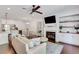 Open concept living room featuring a fireplace, built-in shelving, hardwood floors, and a ceiling fan at 146 Bellehaven Dr, Woodstock, GA 30188