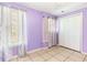 Bright bedroom featuring tile floors, lilac walls, closet, and natural light at 3556 Riley Rd, Douglasville, GA 30134