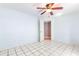 Bright bedroom with white tile floors, ceiling fan, and open doorway at 3556 Riley Rd, Douglasville, GA 30134