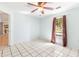 Light and airy bedroom with tile floors, ceiling fan, and window with curtains at 3556 Riley Rd, Douglasville, GA 30134