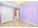 Bedroom featuring tile flooring, closet, lilac walls, and ceiling fan at 3556 Riley Rd, Douglasville, GA 30134