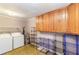 Spacious laundry room featuring washer, dryer, ample storage cabinets and tiled floors at 3556 Riley Rd, Douglasville, GA 30134