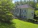 Two-story home with a ramp, side garage, manicured lawn, and mature trees, offering a blend of accessibility and charm at 6797 Lombard Ct, Lithonia, GA 30058