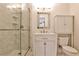Bathroom with a glass shower, white vanity, toilet and cabinet with a rustic-framed mirror at 791 Wylie Se St # 404, Atlanta, GA 30316