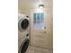 Modern laundry room with a stacked washer and dryer next to a back door at 1327 Rupert Rd, Decatur, GA 30030