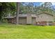 Back exterior showcasing a deck, door to the back yard and mature trees at 6503 Tent Valley Dr, Riverdale, GA 30296