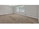 Spacious bedroom with neutral paint, tan carpet and a large window with natural light at 6503 Tent Valley Dr, Riverdale, GA 30296
