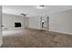 Spacious living room with brick fireplace, ceiling fan, neutral carpet, and view into adjacent kitchen at 6503 Tent Valley Dr, Riverdale, GA 30296