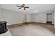 The open living room features a ceiling fan, wood-paneled walls, wood burning stove and access to other rooms at 6503 Tent Valley Dr, Riverdale, GA 30296