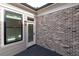 View of a modern back porch with a stylish brick wall, wood floor, and access door, offering a cozy outdoor space at 540 Fisher Dr # 46, Alpharetta, GA 30009