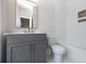 Modern bathroom features a gray vanity, large mirror, and a white tub with tiled wall at 540 Fisher Dr # 46, Alpharetta, GA 30009