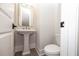 This half bathroom includes a pedestal sink, brushed gold faucet, and light gray wood-look flooring at 540 Fisher Dr # 46, Alpharetta, GA 30009