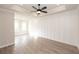 Spacious room with elegant trey ceiling, fan, and light wood-style flooring illuminated by natural light from two windows at 540 Fisher Dr # 46, Alpharetta, GA 30009
