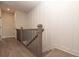 Bright hallway featuring light wood-style flooring, white walls with paneling, and a staircase with black iron railings at 540 Fisher Dr # 46, Alpharetta, GA 30009