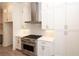 Modern kitchen with white cabinets, stainless steel appliances, and stylish herringbone backsplash at 540 Fisher Dr # 46, Alpharetta, GA 30009