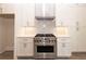 Modern kitchen featuring stainless steel stove, range hood, white cabinets, and bright backsplash at 540 Fisher Dr # 46, Alpharetta, GA 30009