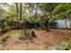 Private backyard featuring mature trees, mulched ground cover, and a charming pergola-covered patio area at 570 Park Se Ave, Atlanta, GA 30312