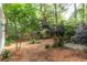 Spacious backyard featuring mature trees, mulched ground cover, and a charming pergola-covered patio area at 570 Park Se Ave, Atlanta, GA 30312