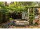 Pergola-covered patio in a serene backyard setting, featuring lush greenery, mature trees, and access to garage at 570 Park Se Ave, Atlanta, GA 30312