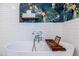 Clean bathroom with a standalone soaking tub, patterned wallpaper, and subway tile walls at 570 Park Se Ave, Atlanta, GA 30312