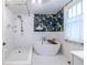 Modern bathroom with white subway tile, stylish wallpaper, and a standalone soaking tub at 570 Park Se Ave, Atlanta, GA 30312