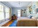Charming bedroom with hardwood floors, bright windows, and eclectic artwork on the wall at 570 Park Se Ave, Atlanta, GA 30312