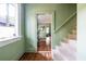 Inviting entryway with hardwood floors, soft green walls and staircase with carpeted steps leading to the upper level at 570 Park Se Ave, Atlanta, GA 30312
