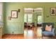 Open-concept living room with green walls, wood floors, and stylish furniture at 570 Park Se Ave, Atlanta, GA 30312