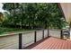 Wood back deck with plank railings offers backyard views with green lawn, mature trees, and a trampoline at 905 Hickory Ridge Sw Rd, Lilburn, GA 30047