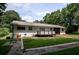 Back exterior view of home with a green lawn, wood deck with plank railings, and mature trees at 905 Hickory Ridge Sw Rd, Lilburn, GA 30047