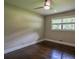 This bedroom has hardwood floors, a ceiling fan, and a window with a view of the outside at 905 Hickory Ridge Sw Rd, Lilburn, GA 30047