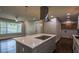 Updated kitchen with an island, stainless steel vent hood, and adjacent seating area at 905 Hickory Ridge Sw Rd, Lilburn, GA 30047