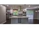 Modern kitchen with stainless steel appliances, gray cabinets, and an island with wine rack at 905 Hickory Ridge Sw Rd, Lilburn, GA 30047