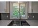 Updated kitchen with a stainless steel sink, white cabinets, and a large window at 905 Hickory Ridge Sw Rd, Lilburn, GA 30047