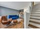 View of the living room with hardwood floors, blue sofa, leather chair and stairs at 2232 Dunseath Nw Ave # 309, Atlanta, GA 30318