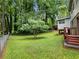 Sprawling backyard surrounded by mature trees with a small tree in the middle of the yard at 784 San Miguel Dr, Stone Mountain, GA 30083
