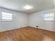 Spacious bedroom with hardwood style floors and bright white walls with dual windows at 784 San Miguel Dr, Stone Mountain, GA 30083
