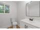Modern bathroom featuring a white vanity, toilet, and a window to let in natural light at 3008 Ridgeside Ct, Atlanta, GA 30341