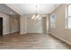 Elegant dining room featuring hardwood floors, a modern chandelier, and natural light from two windows at 4000 Red Canoe Bnd, Lilburn, GA 30047