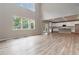 Sun-filled living room with hardwood floors, a modern kitchen, and expansive windows overlooking a green landscape at 4000 Red Canoe Bnd, Lilburn, GA 30047
