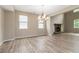 Bright living room featuring a stone fireplace, wood floors, and a decorative chandelier at 4000 Red Canoe Bnd, Lilburn, GA 30047
