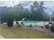 Community pool with black metal fence, seating, and plenty of green space and mature trees at 4000 Red Canoe Bnd, Lilburn, GA 30047