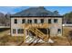 This home has a wooden staircase to the second-story deck and a gray roof and siding at 4400 Ross Estates Ct, Snellville, GA 30039